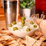 Low carb dirty martini dip with low carb chips on a cutting board