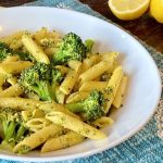 A bowl full of lemon pasta with broccoli.